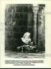 1988 Press Photo A Moslem woman cradles her child beside a wall in Old Jerusalem