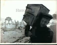 1993 Press Photo Man carries a wood-burning stove near Sarajevo Muslim Cemetery