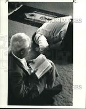 1986 Press Photo A Muslim worshiper reads his Koran as another bows in prayer