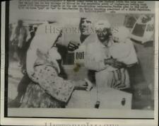 1958 Press Photo A Moslem woman votes as her husband holds the baby - nee00884